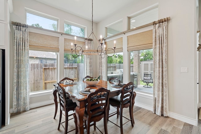 dining room featuring a wealth of natural light, a chandelier, and light wood-type flooring