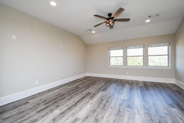 empty room featuring hardwood / wood-style flooring, vaulted ceiling, and ceiling fan