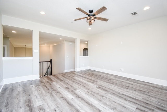 empty room with ceiling fan and light hardwood / wood-style flooring