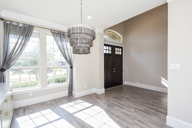 entrance foyer with an inviting chandelier and light hardwood / wood-style flooring