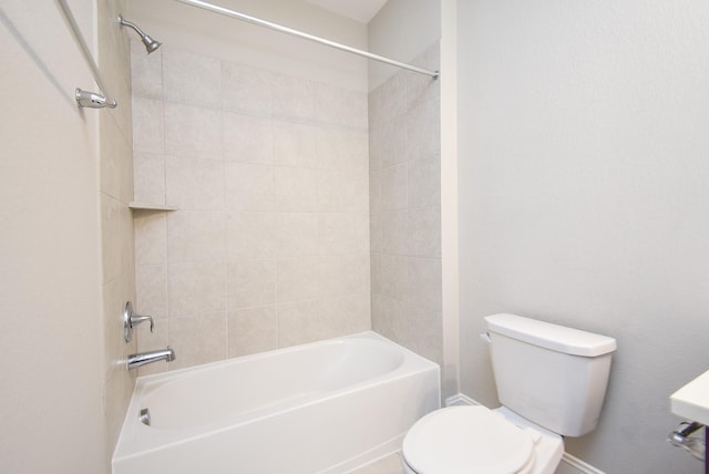 bathroom featuring tiled shower / bath combo and toilet