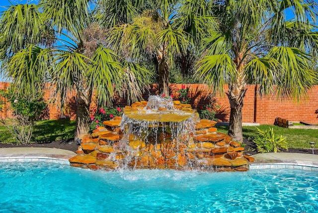 view of swimming pool with pool water feature