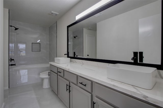 full bathroom featuring tiled shower / bath combo, vanity, and toilet