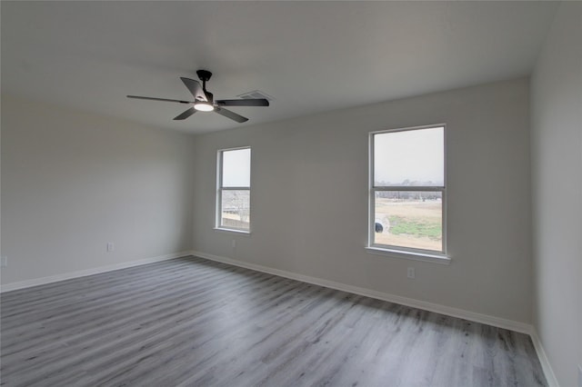 empty room with ceiling fan and light hardwood / wood-style flooring