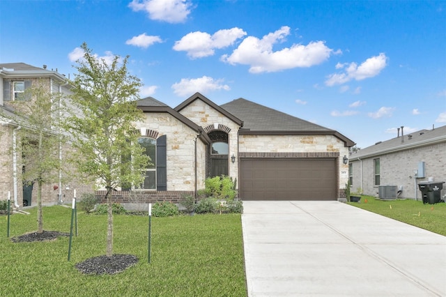 view of front of property featuring a garage, a front lawn, and central air condition unit