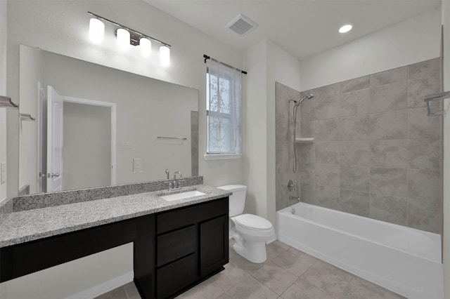 full bathroom featuring vanity, tile patterned flooring, tiled shower / bath combo, and toilet