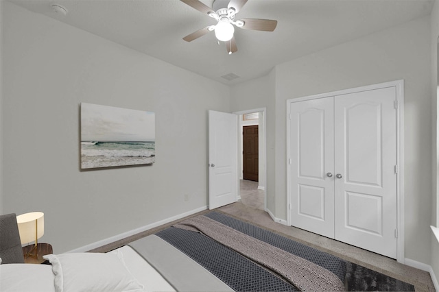 carpeted bedroom featuring ceiling fan and a closet