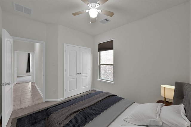 tiled bedroom featuring ceiling fan and a closet