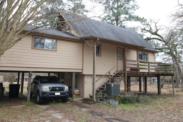 back of house featuring a carport and central AC