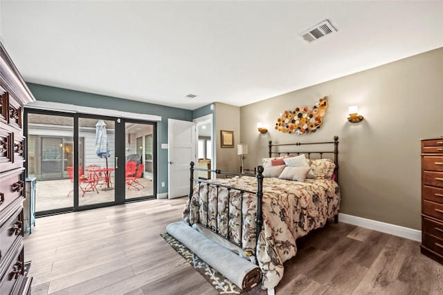 bedroom featuring wood-type flooring and access to exterior