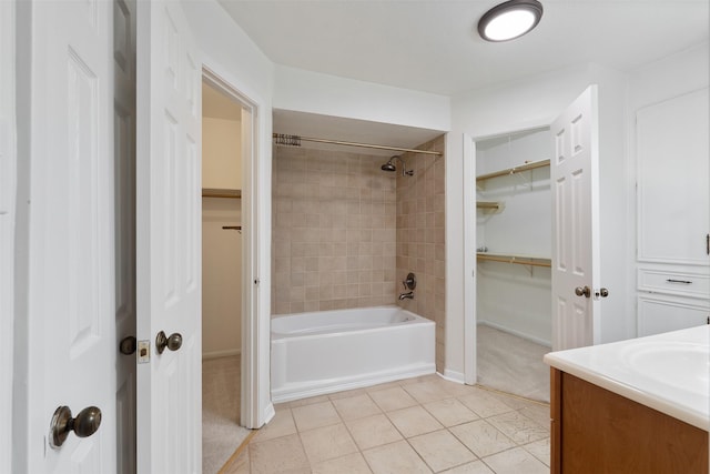 bathroom with tile patterned flooring, vanity, and tiled shower / bath combo