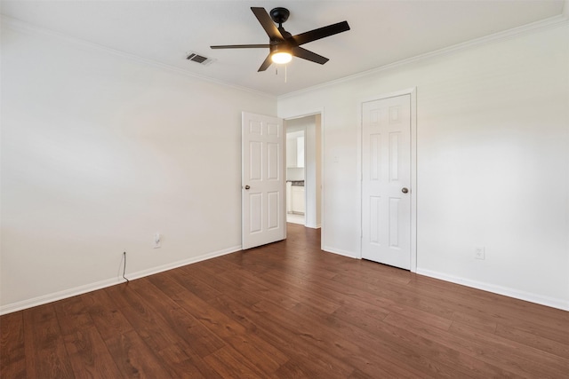 empty room with dark wood-type flooring, ceiling fan, and crown molding