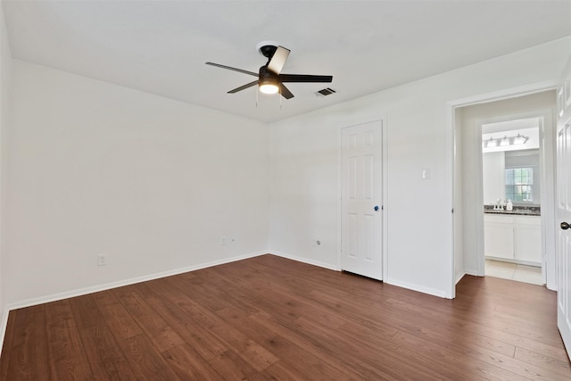 unfurnished bedroom featuring dark wood-type flooring and ceiling fan