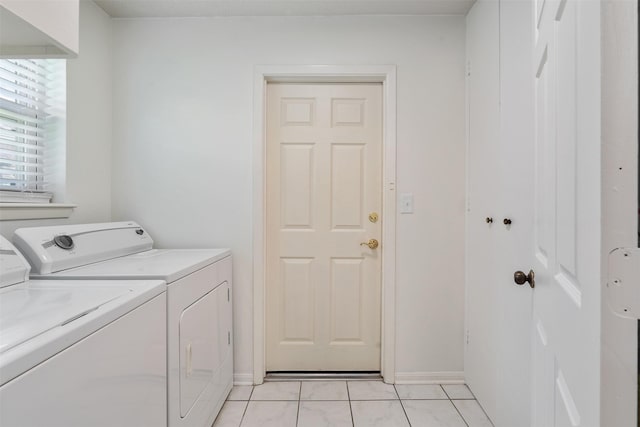 clothes washing area featuring light tile patterned floors and washing machine and clothes dryer