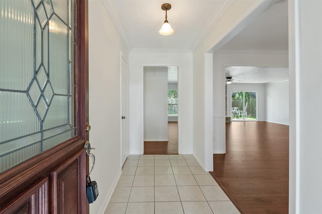 tiled entryway featuring crown molding and ceiling fan