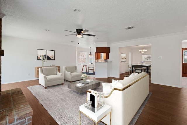 living room featuring dark hardwood / wood-style flooring, ceiling fan with notable chandelier, and a textured ceiling