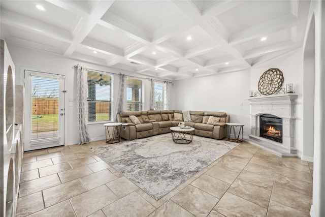 living room featuring coffered ceiling, beamed ceiling, and a lit fireplace