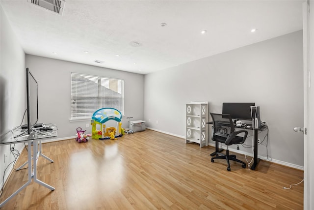 office space with wood finished floors, visible vents, and baseboards