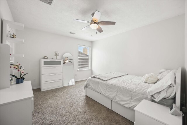 carpeted bedroom with a ceiling fan, visible vents, and baseboards