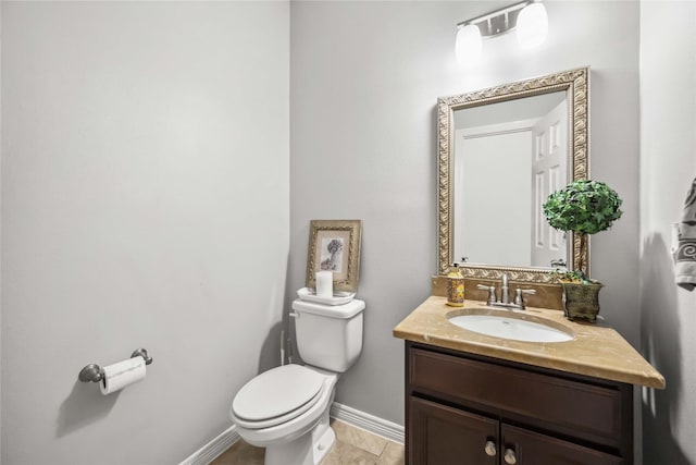 half bathroom with baseboards, vanity, and toilet