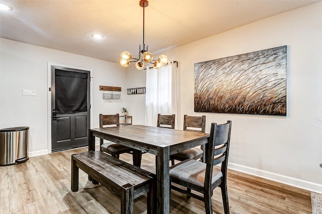 dining space with a notable chandelier and light hardwood / wood-style floors