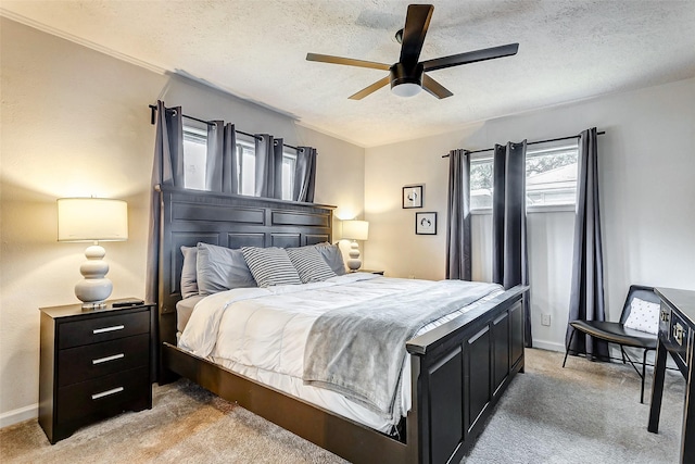 carpeted bedroom featuring ceiling fan and a textured ceiling