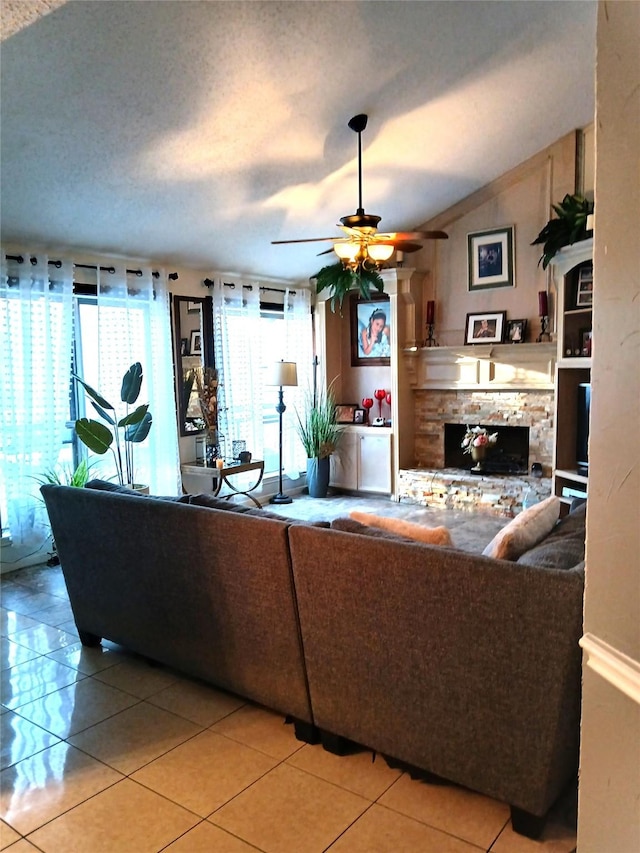 living room with a fireplace, tile patterned floors, ceiling fan, and vaulted ceiling