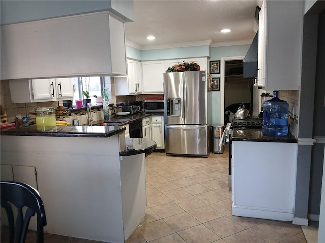 kitchen featuring white cabinetry, backsplash, stainless steel appliances, and kitchen peninsula