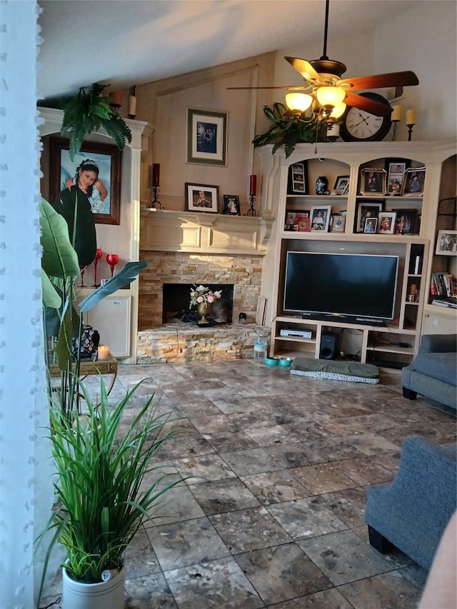 living room featuring vaulted ceiling, ceiling fan, a fireplace, and built in shelves