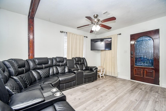 living room with a textured ceiling, light hardwood / wood-style flooring, and ceiling fan