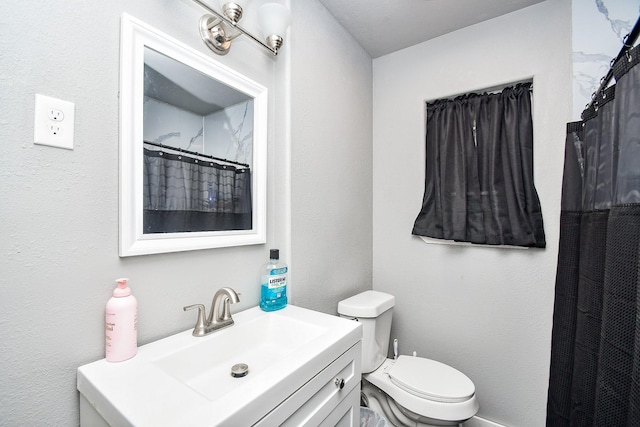 bathroom featuring vanity, walk in shower, and toilet