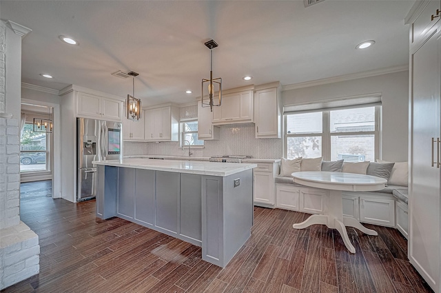 kitchen featuring white cabinetry, hanging light fixtures, and stainless steel refrigerator with ice dispenser