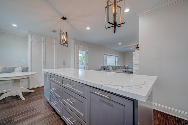 kitchen with a kitchen island, dark hardwood / wood-style floors, decorative light fixtures, gray cabinetry, and ornamental molding