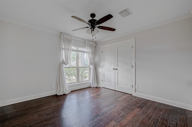 unfurnished bedroom featuring dark hardwood / wood-style flooring, crown molding, and ceiling fan