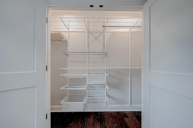 walk in closet with dark hardwood / wood-style flooring