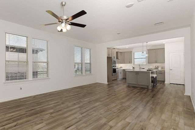 unfurnished living room with ceiling fan, dark hardwood / wood-style floors, and sink