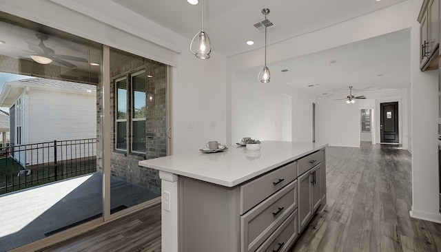 kitchen with a kitchen island, gray cabinetry, pendant lighting, and dark wood-type flooring