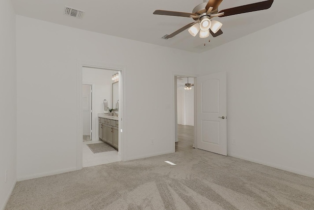 unfurnished bedroom with connected bathroom, light carpet, and ceiling fan