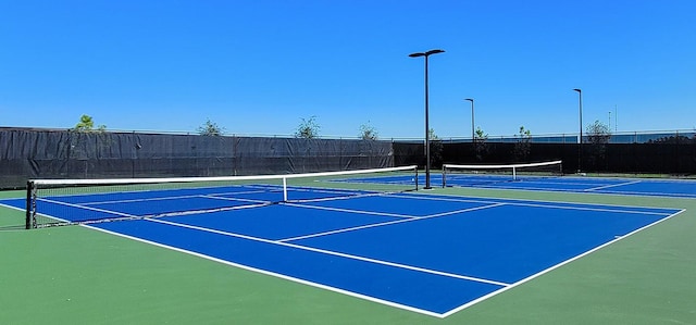 view of tennis court with basketball hoop