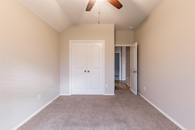 unfurnished bedroom featuring lofted ceiling, carpet flooring, ceiling fan, and a closet