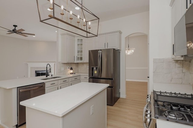 kitchen featuring ceiling fan, hanging light fixtures, stainless steel appliances, a center island, and white cabinets