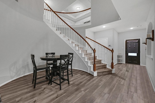 2509 Ocean Key Dr, Texas City, TX 77568 - dining area with stairway, wood finished floors, baseboards, a high ceiling, and recessed lighting