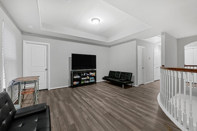 sitting room with dark hardwood / wood-style floors and a raised ceiling