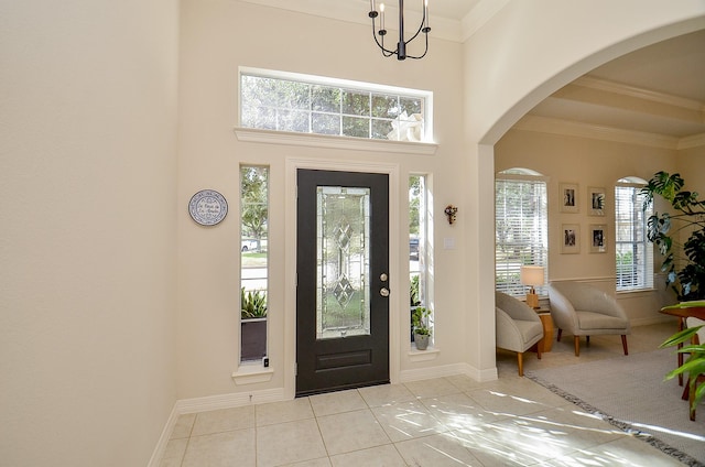 entrance foyer featuring ornamental molding, a high ceiling, and light tile patterned floors