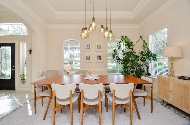 tiled dining area with crown molding and a raised ceiling