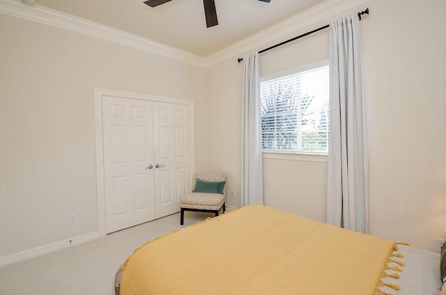 carpeted bedroom featuring crown molding, a closet, and ceiling fan