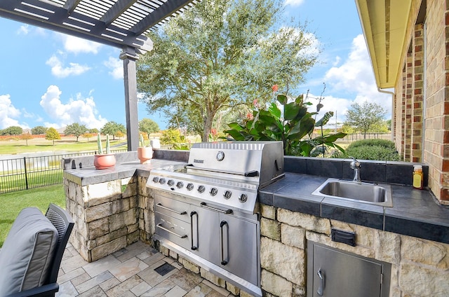 view of patio / terrace with a grill, a pergola, exterior kitchen, and sink