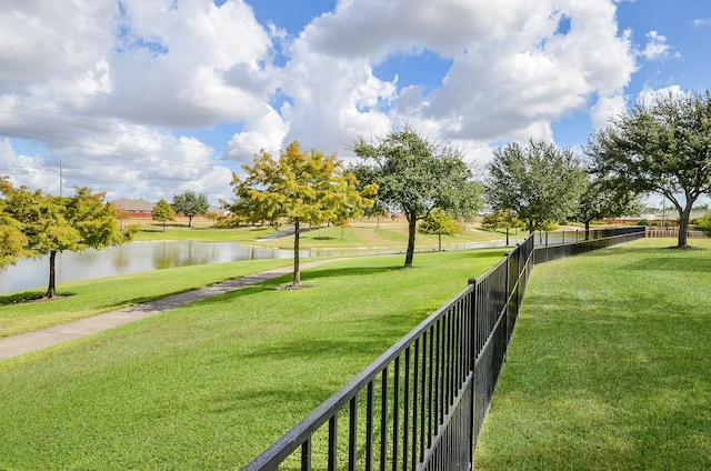 surrounding community featuring a water view and a lawn