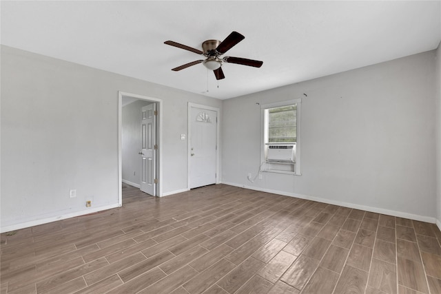 spare room featuring cooling unit, light hardwood / wood-style flooring, and ceiling fan