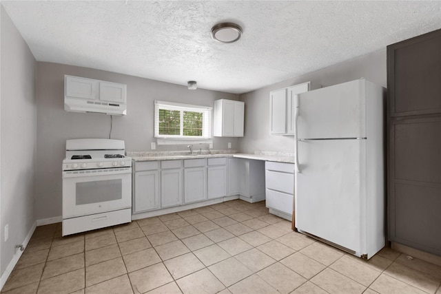 kitchen with sink, white appliances, light tile patterned floors, white cabinetry, and a textured ceiling